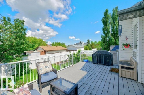 Spacious outdoor deck featuring composite decking, white railing, and exterior wall siding - 5528 43 Street, Lamont, AB 