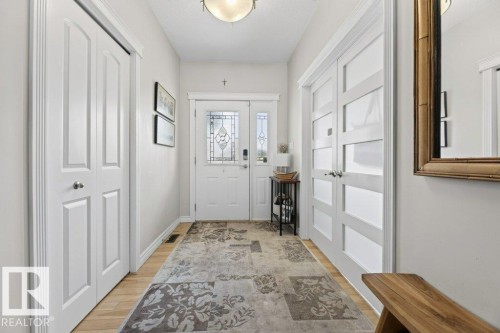 Bright entryway featuring light wood-finish flooring and white trim - 5528 43 Street, Lamont, AB 