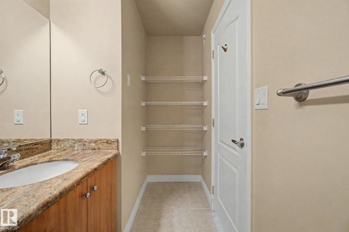Bathroom vanity with stone-finish countertop, undermount sink, and wood-finish cabinetry - 413 10116 80 Avenue, Edmonton, AB 