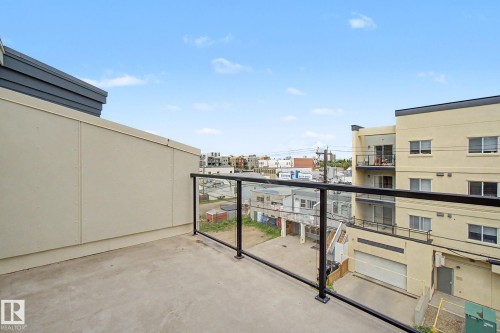 Private outdoor balcony space featuring a concrete surface and contemporary glass railing with black metal posts - 413 10116 80 Avenue, Edmonton, AB 