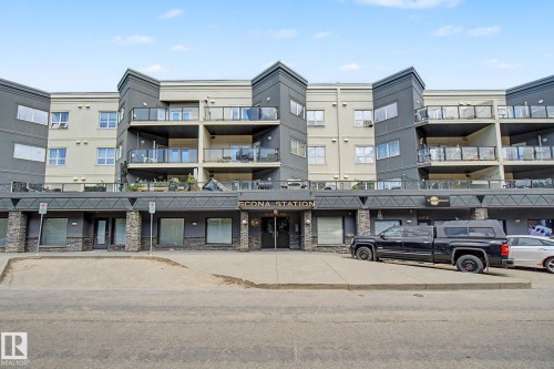 Contemporary multi-story building featuring a two-tone facade, ground-floor commercial spaces, private balconies with glass railings, stone-clad architectural details, and a prominent main entrance - 413 10116 80 Avenue, Edmonton, AB 