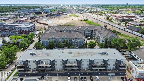 Contemporary residential building featuring private balconies, multi-story design, and an integrated parking area - 413 10116 80 Avenue, Edmonton, AB 