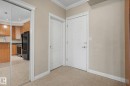 Foyer featuring neutral wall tones, crown molding, and tile flooring - 413 10116 80 Avenue, Edmonton, AB 