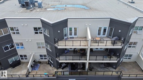 Multi-level building exterior featuring a modern façade with contrasting light and dark paneling - 413 10116 80 Avenue, Edmonton, AB 