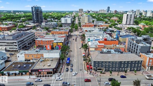 Urban streetscape featuring multi-story commercial buildings, a wide thoroughfare, and a city skyline - 413 10116 80 Avenue, Edmonton, AB 
