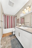Bathroom featuring a white vanity with double doors and silver hardware, a single basin sink, and a gray countertop - 