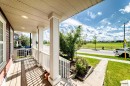 Covered front porch with wood-finish flooring and white railings - 875 Chappelle Link Link, Edmonton, AB 