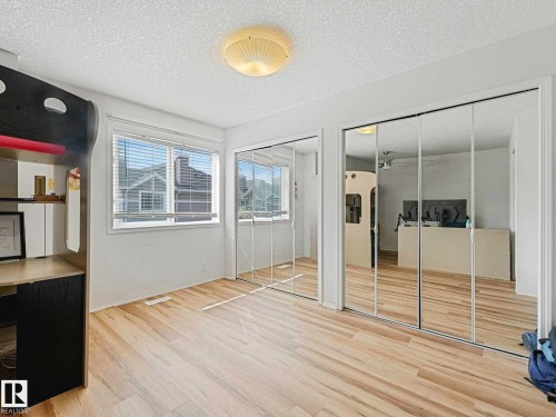 Light wood-finish flooring with white walls and a textured ceiling - 62 3075 Trelle Crescent Nw, Edmonton, AB - Indoor Photo Showing Other Room