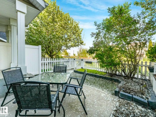 Concrete patio area with a white privacy fence and picket fence - 62 3075 Trelle Crescent Nw, Edmonton, AB - Outdoor With Exterior