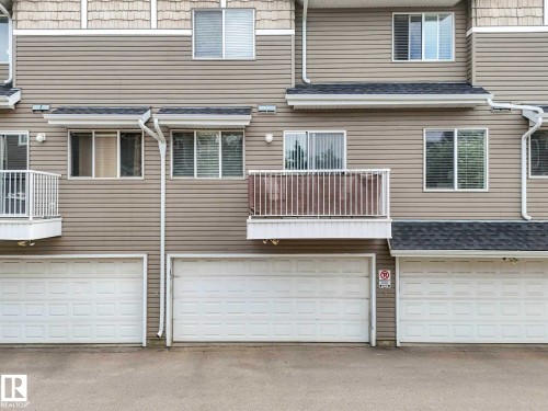 Multi-level townhome exterior featuring light-toned horizontal siding and white trim - 62 3075 Trelle Crescent Nw, Edmonton, AB - Outdoor With Exterior