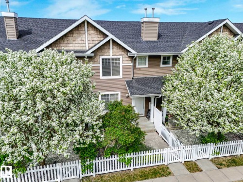 Two-story townhouse exterior with a pitched roof, multiple windows, and a prominent front entrance - 62 3075 Trelle Crescent Nw, Edmonton, AB - Outdoor