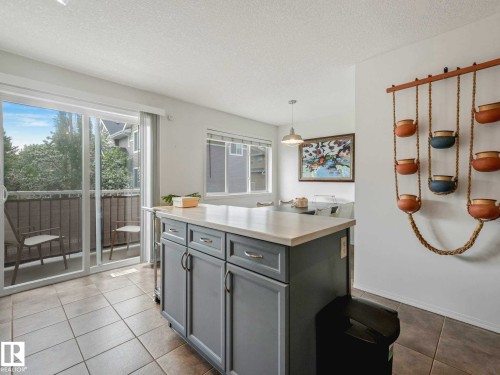 Kitchen island with light gray cabinetry and a light-toned countertop - 62 3075 Trelle Crescent Nw, Edmonton, AB - Indoor Photo Showing Other Room