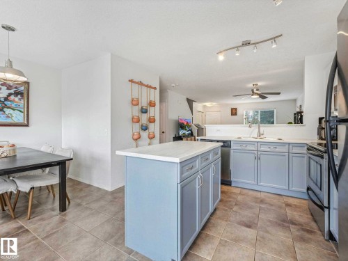 Kitchen featuring a central island with light blue cabinetry and a light-colored countertop - 62 3075 Trelle Crescent Nw, Edmonton, AB - Indoor Photo Showing Kitchen