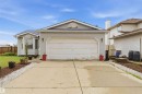 Exterior featuring light gray siding, an attached two-car garage, a bay window, and a concrete driveway - 4428 11A Avenue, Edmonton, AB 