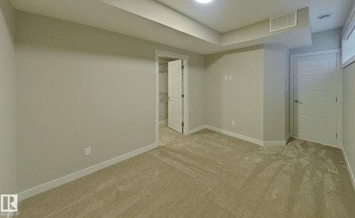 Carpeted room featuring light gray walls, white trim, and a white paneled door - #Basement 10923 159 St Nw, Edmonton, AB - Indoor Photo Showing Other Room
