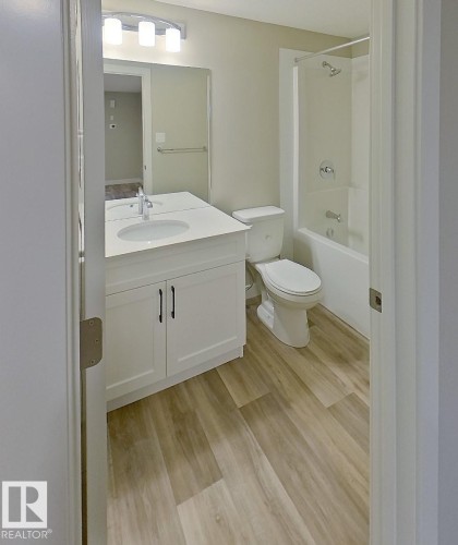 Modern bathroom featuring a white vanity with integrated sink, a rectangular mirror, and an overhead light fixture - #Basement 10923 159 St Nw, Edmonton, AB - Indoor Photo Showing Bathroom