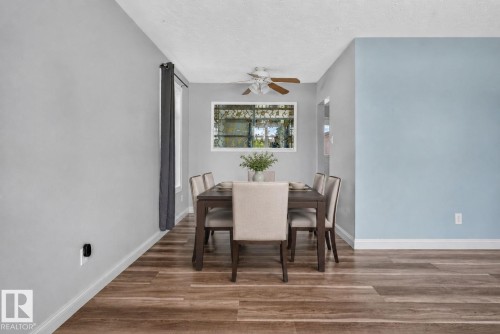 Dining area featuring wood-finish flooring, a white window frame, and a ceiling fan with light fixture - 13431 109 Street, Edmonton, AB 