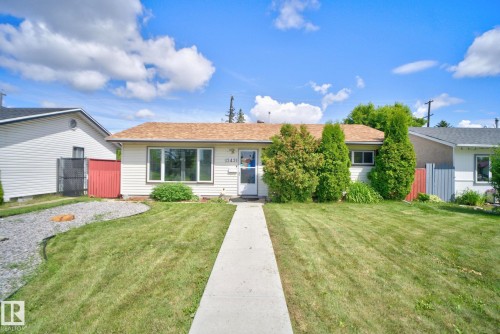 Single-story residence featuring light-colored siding, a brown shingle roof, and a prominent front window - 13431 109 Street, Edmonton, AB 