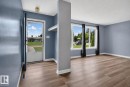 Wood-finish flooring throughout, featuring a bright entry with a full-light door and a built-in shelving unit - 13431 109 Street, Edmonton, AB 