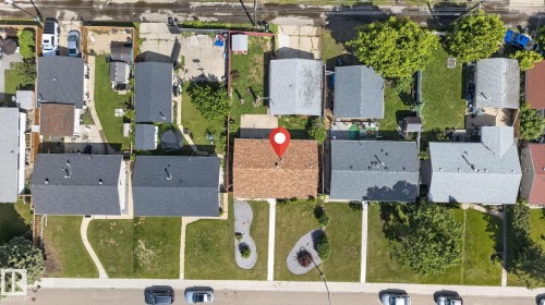 Aerial perspective showcasing a residential property with a brown shingle roof, a paved driveway, and a fenced backyard - 13431 109 Street, Edmonton, AB 