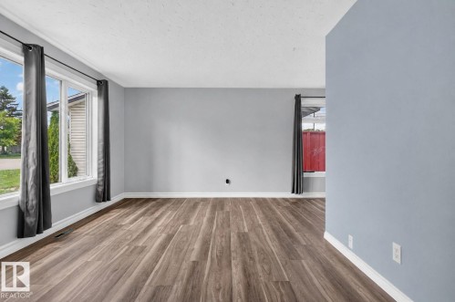 Interior room featuring wood-finish flooring, light grey walls, and white baseboards - 13431 109 Street, Edmonton, AB 