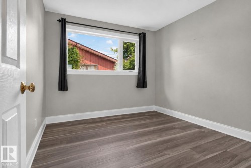 Room with wood-finish flooring, a white window frame, and gray painted walls - 13431 109 Street, Edmonton, AB 