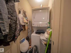 Dedicated laundry area featuring a stacked washer and dryer unit - 