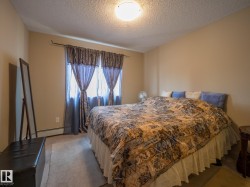 Carpeted room with a ceiling-mounted light fixture and neutral-toned walls - 
