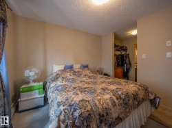 Carpeted bedroom featuring neutral wall paint, a textured ceiling, and an integrated closet area - 