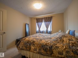 Carpeted interior room with neutral-toned walls and a textured ceiling - 