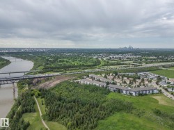 Expansive aerial perspective showcasing a river, a multi-lane bridge, and a forested river valley - 