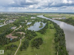 Expansive aerial perspective showcasing a significant river, numerous natural lakes, and abundant mature trees - 