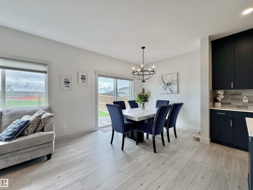 Bright open-concept dining area with wood-finish flooring - 33 Sumac Close, Fort Saskatchewan, AB 