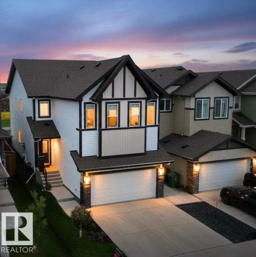 Modern Tudor-inspired exterior with white siding, dark trim, and a prominent front gable - 33 Sumac Close, Fort Saskatchewan, AB 