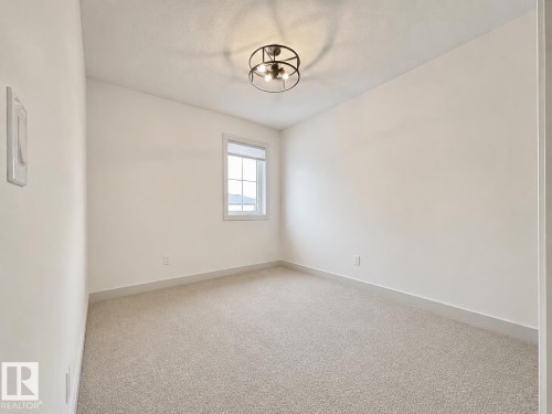 Neutral wall paint, light-toned carpeting, and a window with blinds - 33 Sumac Close, Fort Saskatchewan, AB 