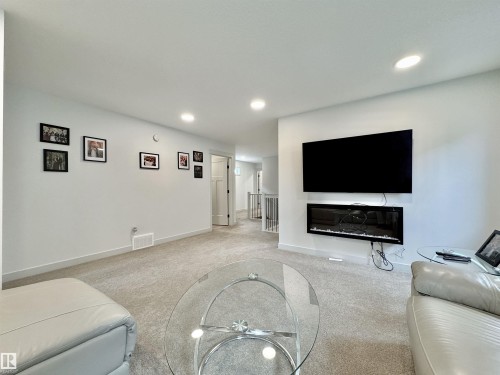 Spacious living area featuring light-toned carpeting and recessed lighting - 33 Sumac Close, Fort Saskatchewan, AB 