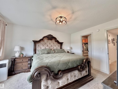 Spacious bedroom featuring light-colored walls and soft carpet flooring - 33 Sumac Close, Fort Saskatchewan, AB 