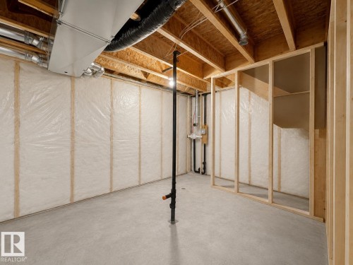 Unfinished basement featuring exposed wood joists, concrete flooring, and insulated walls - 33 Sumac Close, Fort Saskatchewan, AB 