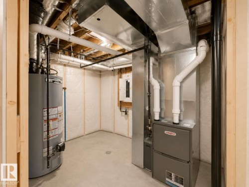 Utility room featuring a water heater, furnace, exposed ductwork, and concrete flooring - 33 Sumac Close, Fort Saskatchewan, AB 