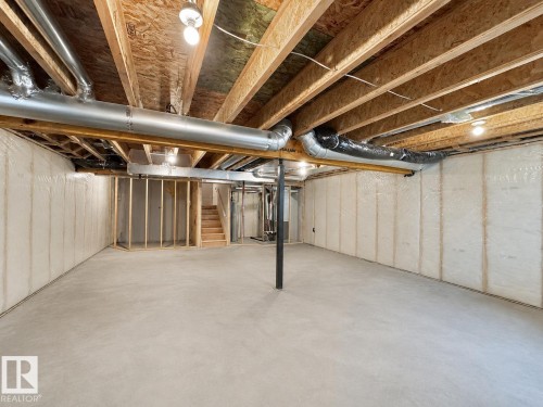 Spacious unfinished lower level featuring exposed wood joists and concrete flooring - 33 Sumac Close, Fort Saskatchewan, AB 