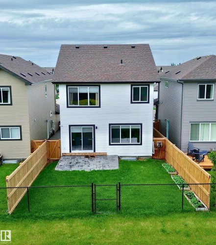 Rear exterior featuring white horizontal siding and dark trim windows - 33 Sumac Close, Fort Saskatchewan, AB 