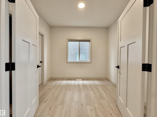 Light wood-finish flooring complements the neutral wall color in this room - 33 Sumac Close, Fort Saskatchewan, AB 