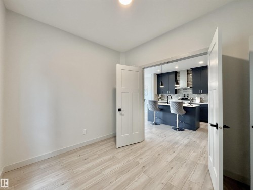 Spacious room with wood-finish flooring and light-toned walls - 33 Sumac Close, Fort Saskatchewan, AB 