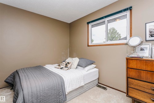 Carpeted room with a sliding window featuring a wood-finish frame and dark blue blind - 14231 80 Street, Edmonton, AB 