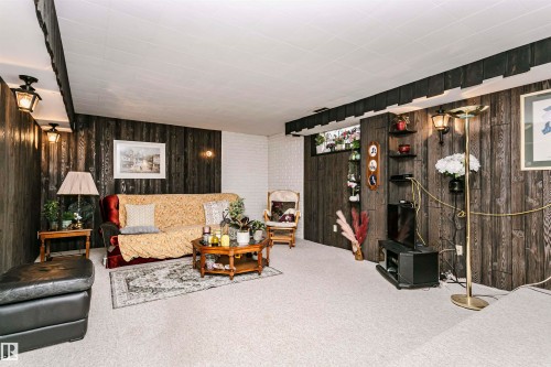 Carpeted room featuring dark wood-paneled walls and a white acoustic tile ceiling - 14231 80 Street, Edmonton, AB 