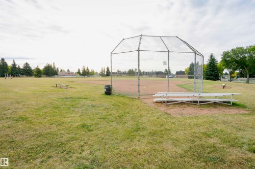 Baseball field featuring a backstop, dugouts, and surrounding grass areas - 14231 80 Street, Edmonton, AB 