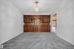 Built-in wood cabinetry featuring glass-front uppers and solid wood base storage, accented by a centered mirror - 