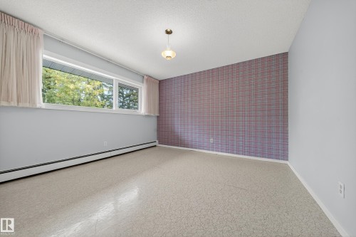 Bright interior space with patterned flooring and a large horizontal window - 707 65 Avenue, Edmonton, AB 