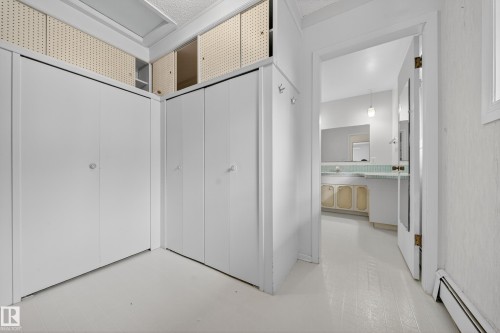 White interior featuring built-in white closet doors and overhead storage - 707 65 Avenue, Edmonton, AB 