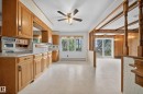 Kitchen featuring wood cabinetry, laminate countertops, and a built-in oven - 707 65 Avenue, Edmonton, AB 